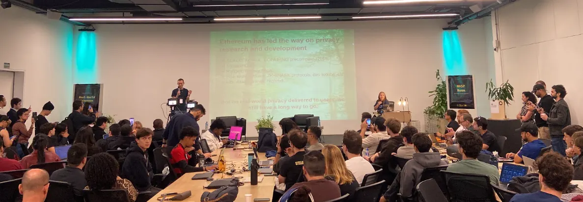 Speakers presenting in front of a projection screen at a hack house